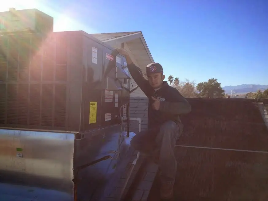 HVAC technician performing Heat Pump Repair on a rooftop unit in Maumelle